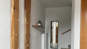A hallway with wooden doors, a coat rack, and a staircase leading to another floor. - Vacation home in Eschweiler - relaxation near the Eifel (Eschweiler)
