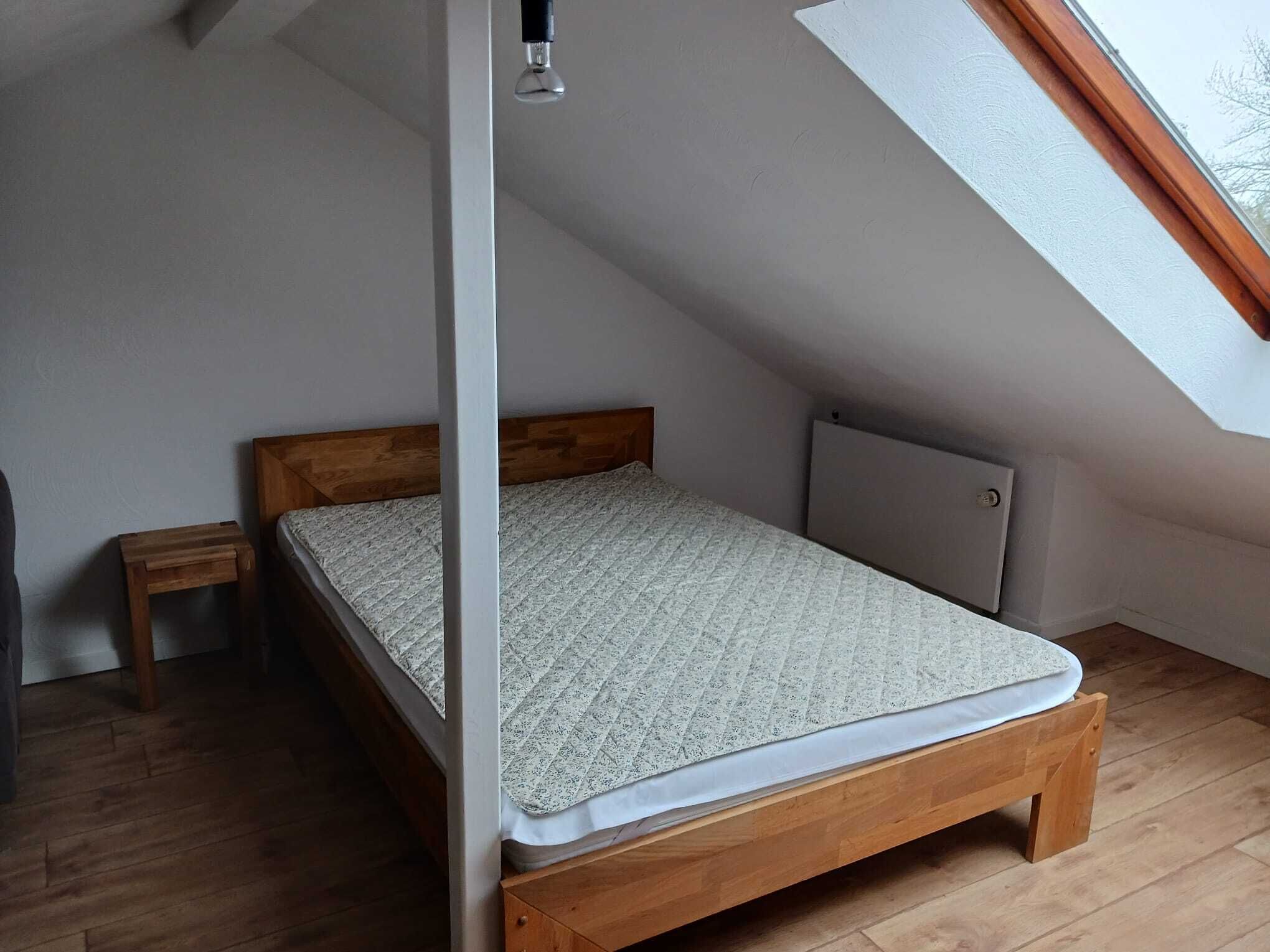 A small, single-bed room with a sloped ceiling and a skylight.