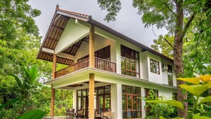 A two-story house with a balcony, surrounded by lush greenery. - Luxury retreat resort in Natural Harmony in Pemuteran! (bali)
