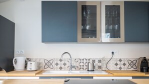 Eine moderne Küche mit Backofen, Spüle und einer Arbeitsplatte, auf der ein Wasserkocher und ein Toaster stehen.