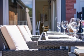 An outdoor dining area with wicker furniture and clear glassware. - [Charmante] Villa proche Centre-ville et Bassin (Arcachon)