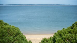 A beach with a clear view of the sea and distant land. - Appartement 145m², Vue Mer, Parking, Accès Plage (Arcachon)