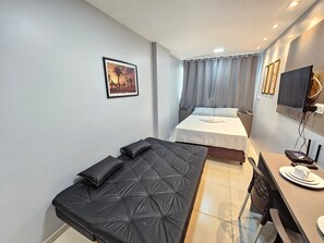 A modern hotel room with a bed, a sofa, a desk, and a TV. - Eco Mirage Residence (Ipojuca)