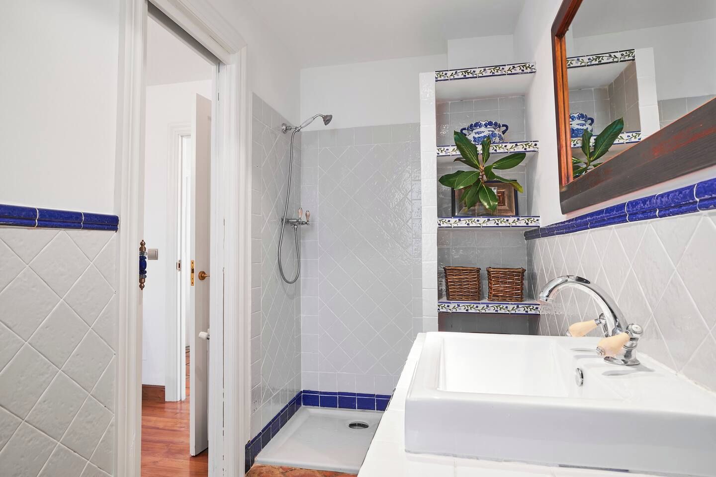 A bathroom with a shower, a sink, and a mirror.