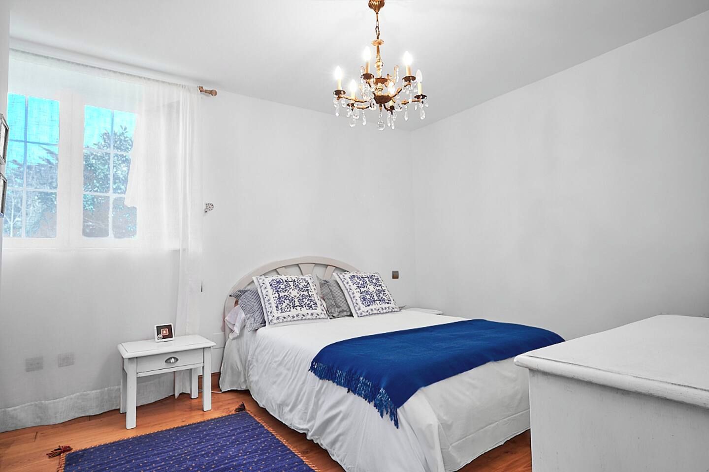Ein Schlafzimmer mit Bett, Nachttisch und Beistelltisch.