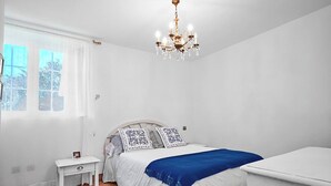 Een slaapkamer met een bed, nachtkastje en een bijpassende tafel.