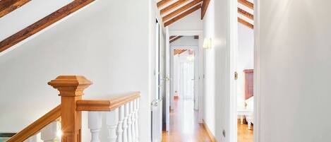 Una escalera de madera con barandillas blancas que conduce a un piso superior.