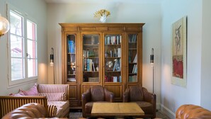 Un salon chaleureux avec des canapés en cuir, une table basse en bois et une grande bibliothèque remplie de livres.