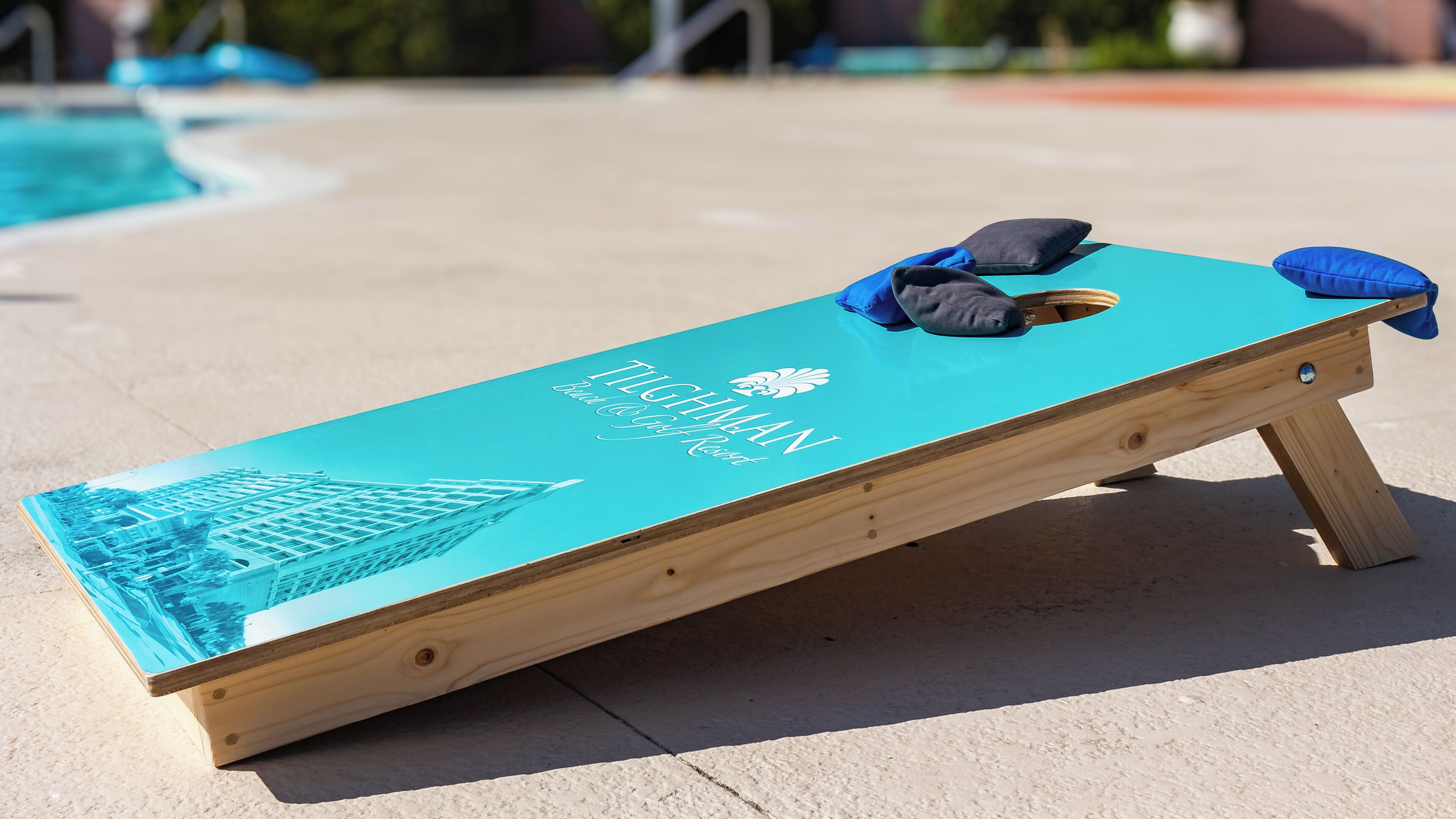 A wooden board with a blue top and a logo, placed on a concrete surface.