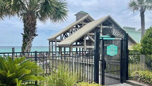 Entrada a un pabellón de playa con estructura de madera, una puerta y un letrero que indica que es solo para el pabellón de playa.