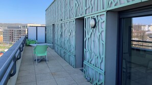 A balcony with a metal railing, a table, and two chairs. - Terres de France - Appart'Hôtel Rouen Flaubert (Rouen)