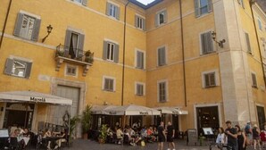 A yellow building with outdoor seating areas and a restaurant named 'Maxela'. - Palazzo Franchi, noble and elegant mansion a few steps from the Pantheon (Roma)