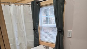 Une salle de bain avec une douche, un lavabo et des toilettes.