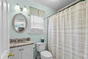 Une salle de bain avec des toilettes, un lavabo et un miroir.