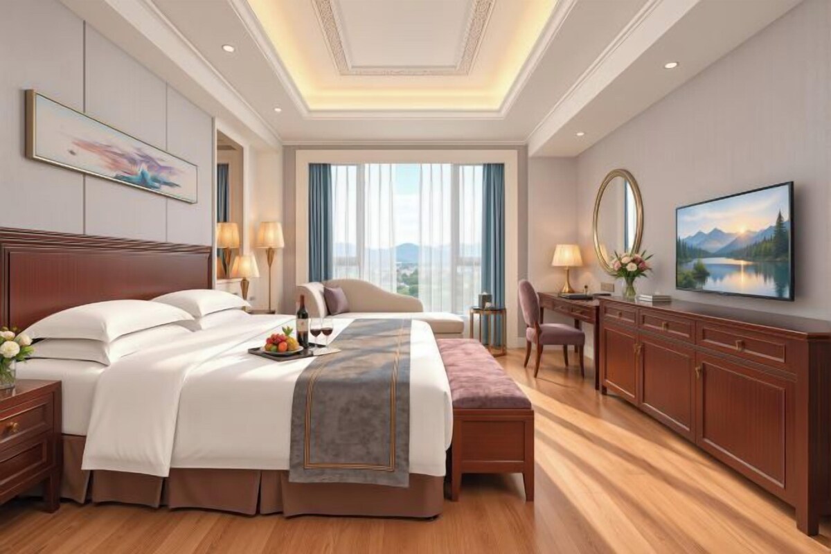 A hotel room with a large bed, a desk, and a view of the city.