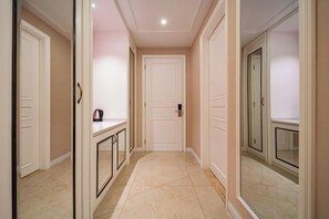 A hallway with a door, a small table with a kettle, and a mirror on the wall. - Jinzhai Hongfu Garden Yuehai Hotel (Dabie Mountain Yuboyuan) (Jinzhai)