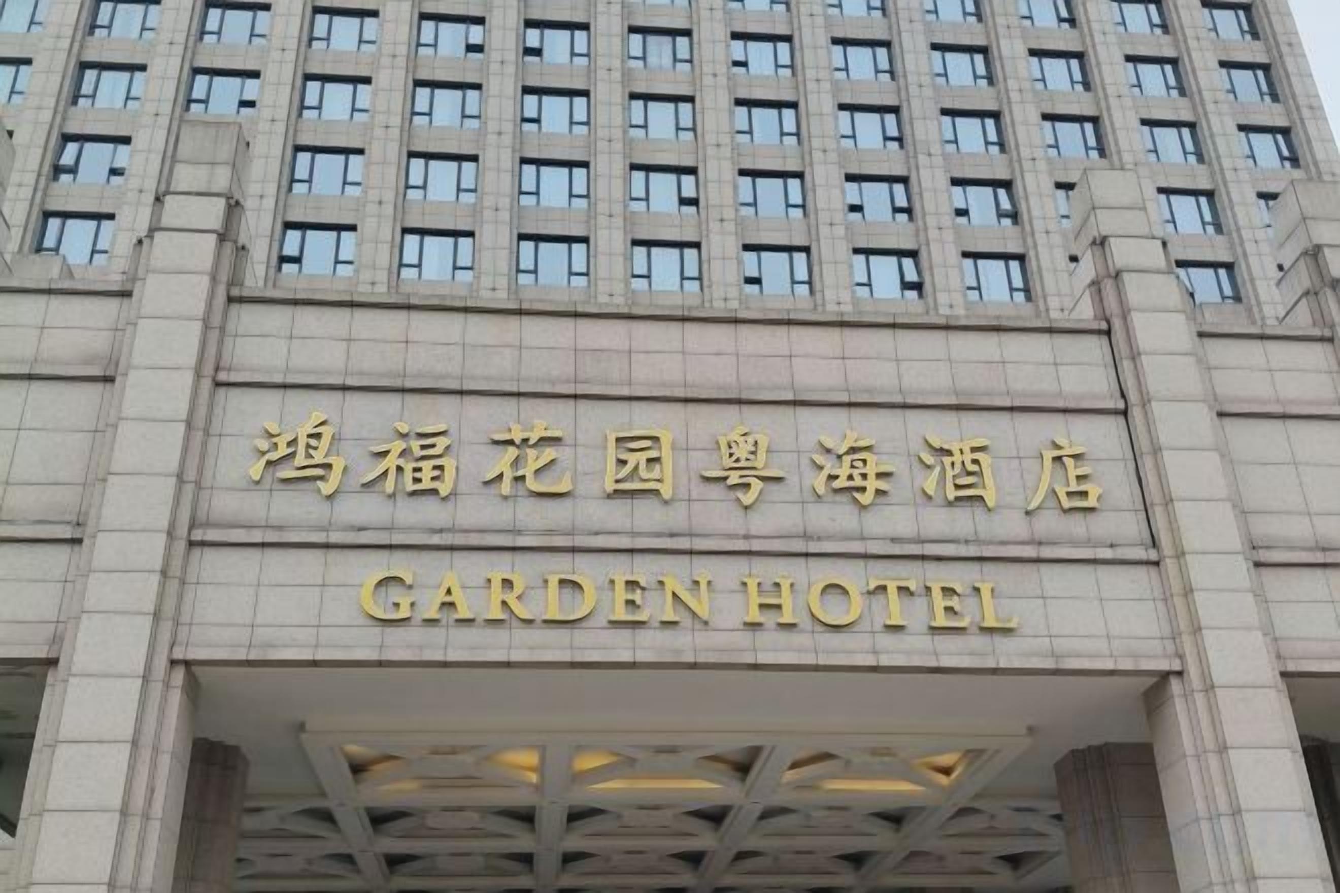 A hotel entrance with a sign in both Chinese and English.