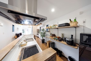 Una cucina moderna con isola centrale, cappa in acciaio inossidabile ed elettrodomestici integrati.