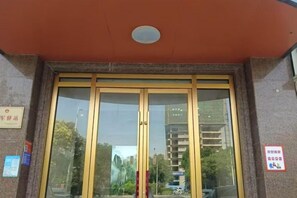 Una entrada de edificio con puerta de vidrio y un letrero encima.