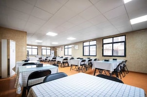 Una sala de conferencias con mesas y sillas dispuestas para reuniones.