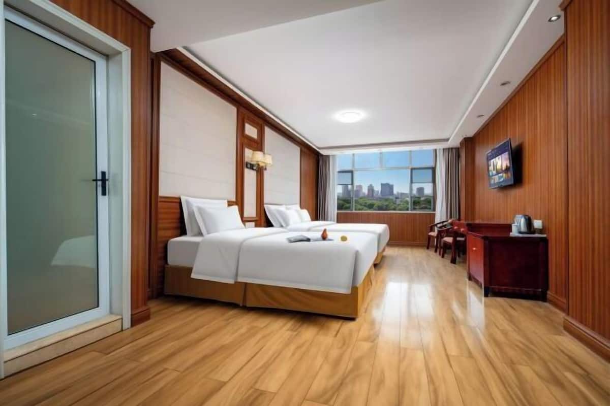 Una habitación de hotel con cama, escritorio, silla y vistas a la ciudad.