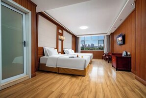 Una habitación de hotel con cama, escritorio, silla y vistas a la ciudad.