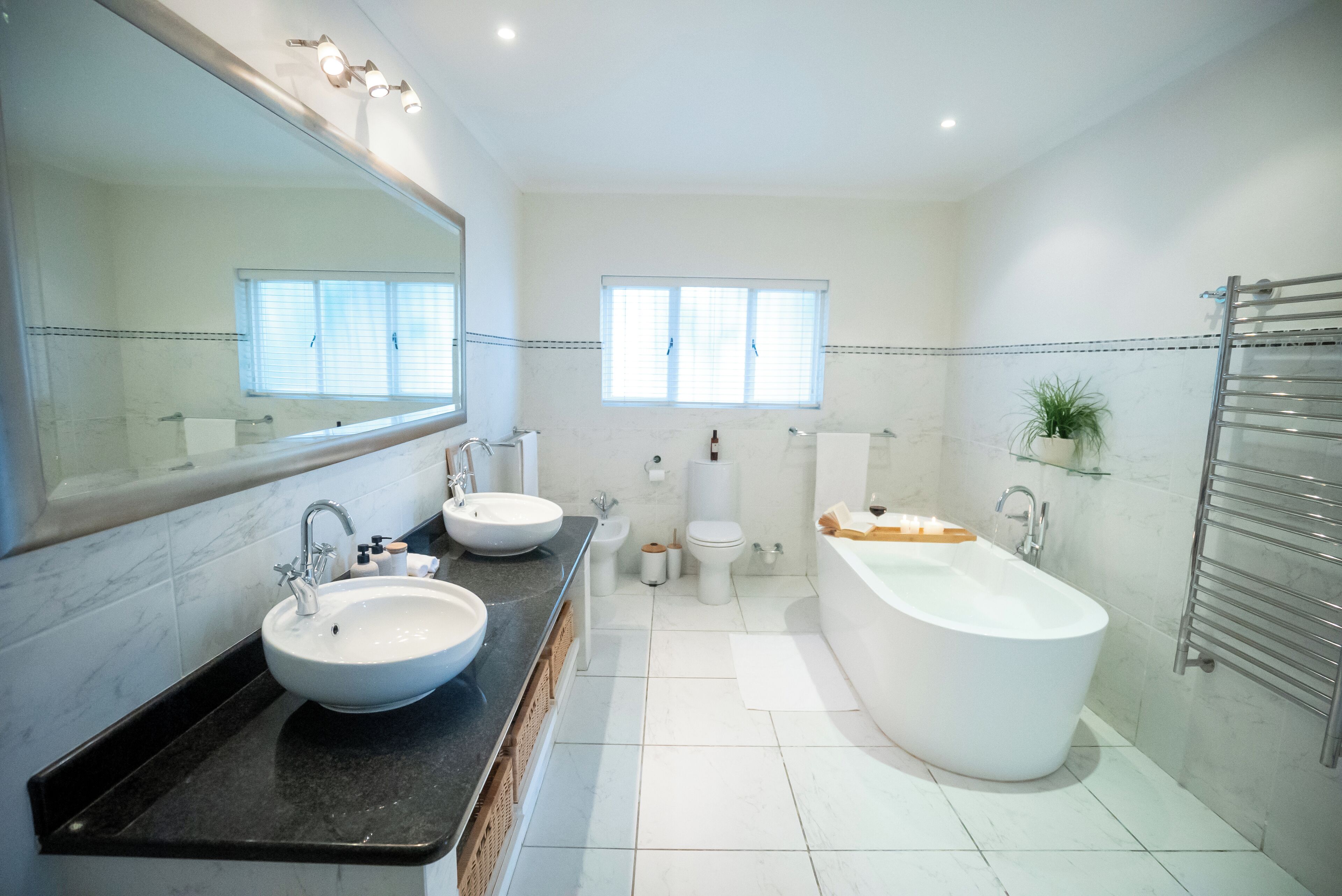 A modern bathroom with a large sink, a bathtub, and a toilet.