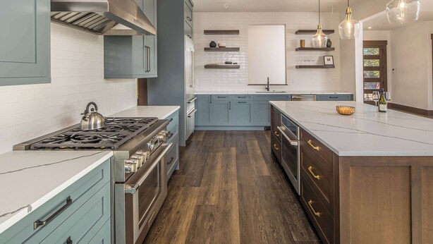 Una cocina con una isla central, electrodomésticos integrados y vistas al exterior.