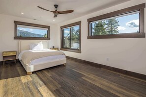 A bedroom with a bed, nightstand, and a ceiling fan.