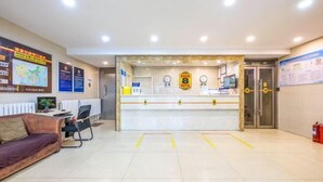 A reception area with a counter, a sofa, a chair, and a fire extinguisher. - Super 8 Hotel (Liujiayao Metro Station) (Beijing)