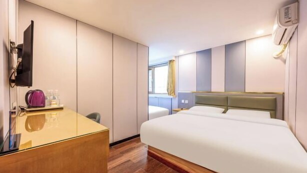 A modern hotel room with a large bed, a desk, a flat-screen TV, and a window with curtains. - Super 8 Hotel (Liujiayao Metro Station) (Beijing)