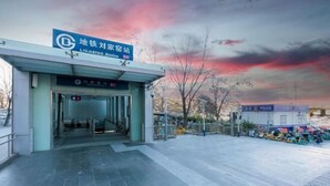 A police station entrance with a sign in a foreign language, a gated driveway, and a police vehicle parked outside. - Super 8 Hotel (Liujiayao Metro Station) (Beijing)