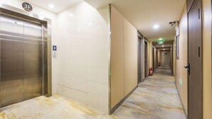 A hotel corridor with an elevator, doors, and a patterned floor. - Super 8 Hotel (Liujiayao Metro Station) (Beijing)