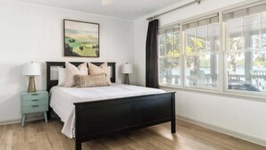 A bedroom with a bed, nightstands, a ceiling fan, a window with curtains, and a painting on the wall. - Wake & Lake - Sleeps 8, Big Water Views! + More! (Sparta)