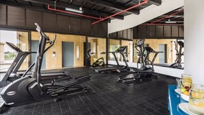 A gym with multiple treadmills, a bench, and a water station.