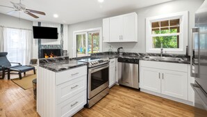 A modern kitchen with white cabinets, a built-in stove, and a dishwasher. - Union Pier Cottage Close To Everything! One Of Three Units! (Union Pier)