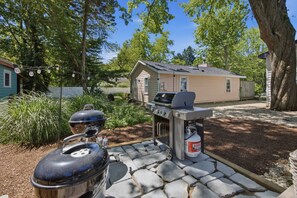 A backyard with a barbecue grill, a gas tank, and a portable oven. - Union Pier Cottage Close To Everything! One Of Three Units! (Union Pier)