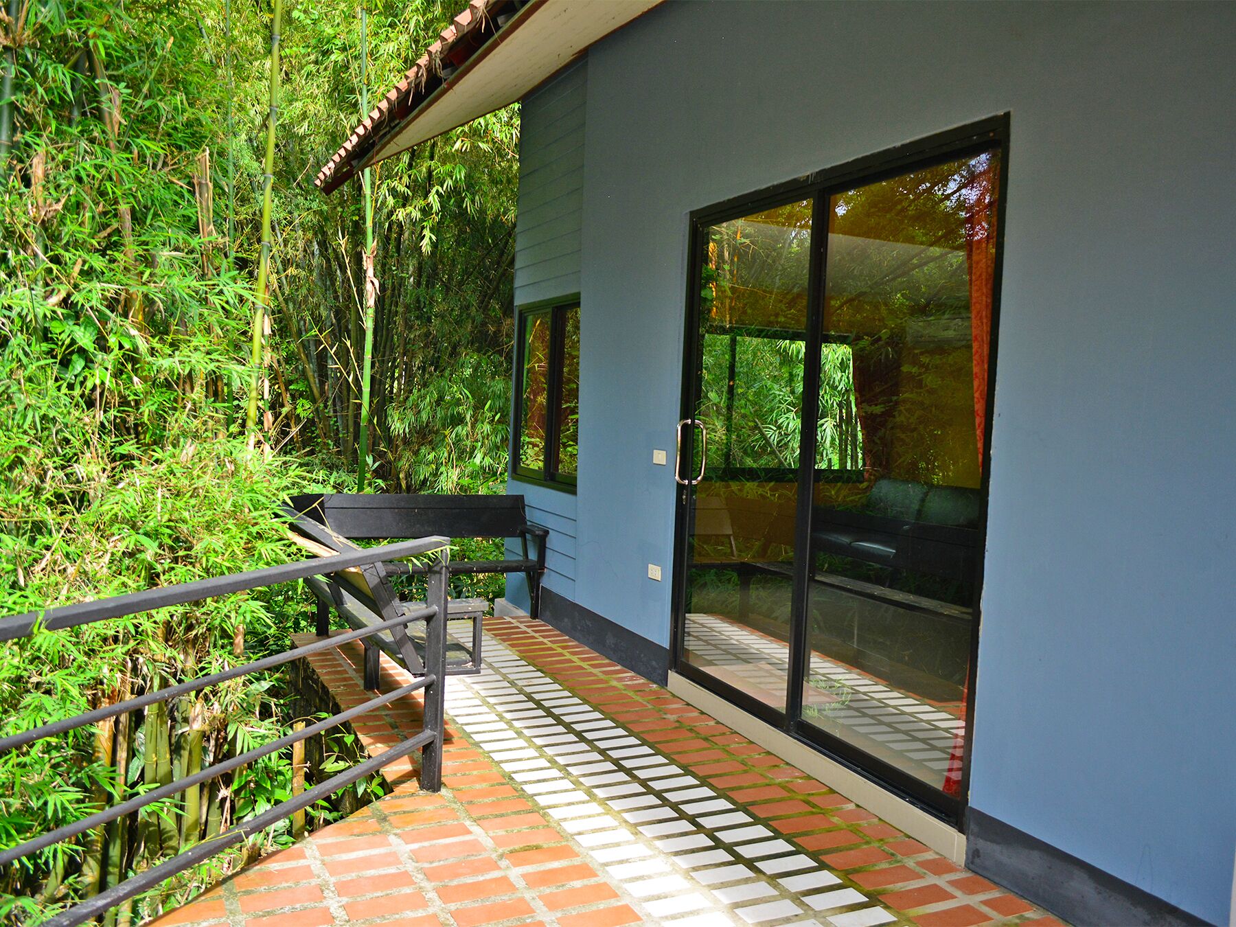 A modern building with a glass door and a metal railing.