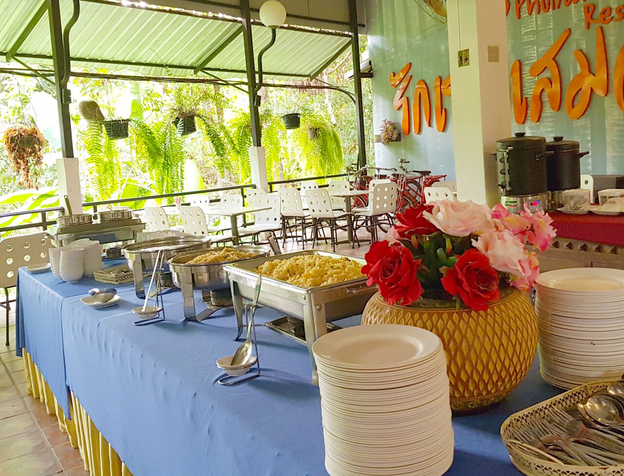 Un buffet garni de divers plats, un vase rempli de fleurs et des assiettes empilées.