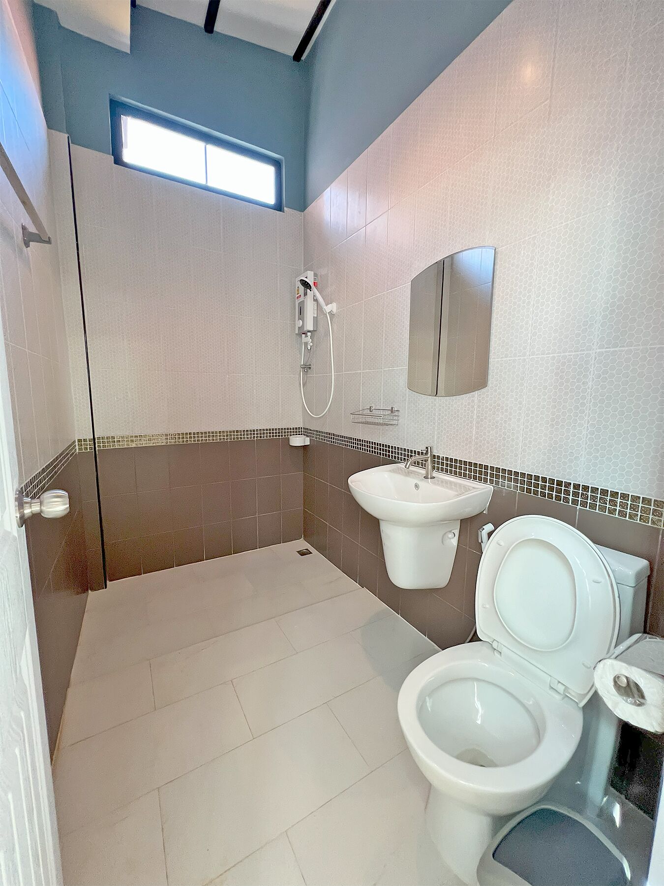 Un baño moderno con ducha, inodoro y lavamanos.