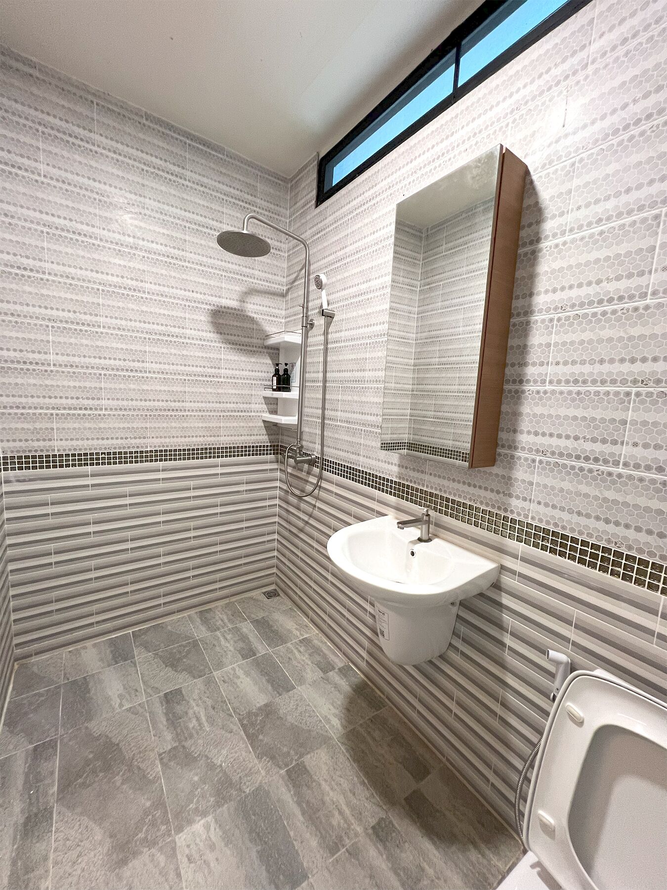 Un baño moderno con ducha, lavabo e inodoro.