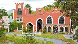 A castle-like building with a clock tower, arched windows, and a sign reading "Castle Town." - Phuiyara Resort Nakhonnayok (Nakhon Nayok)