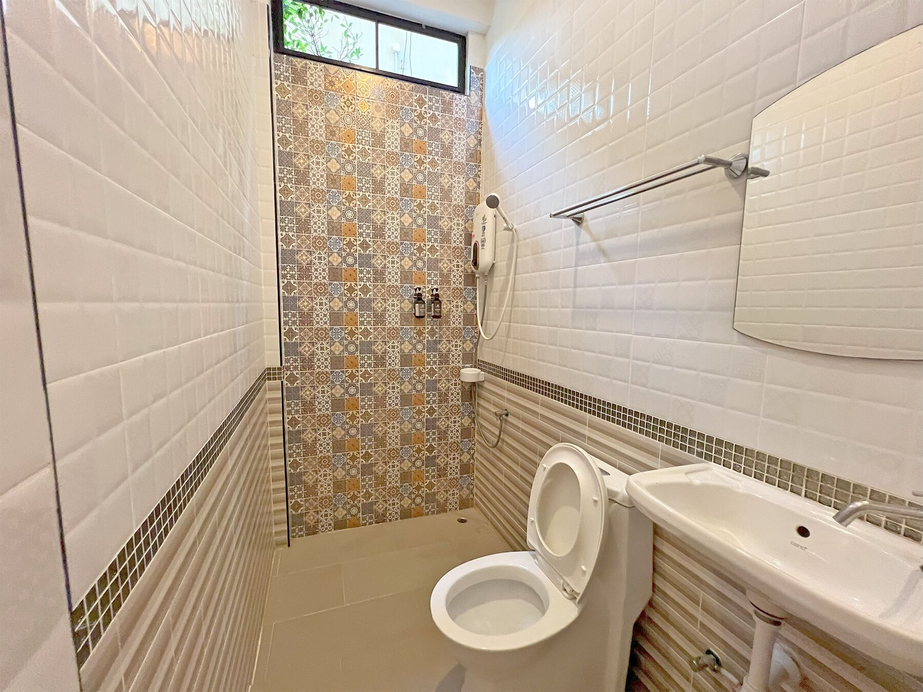 A bathroom with a toilet, sink, and shower area.