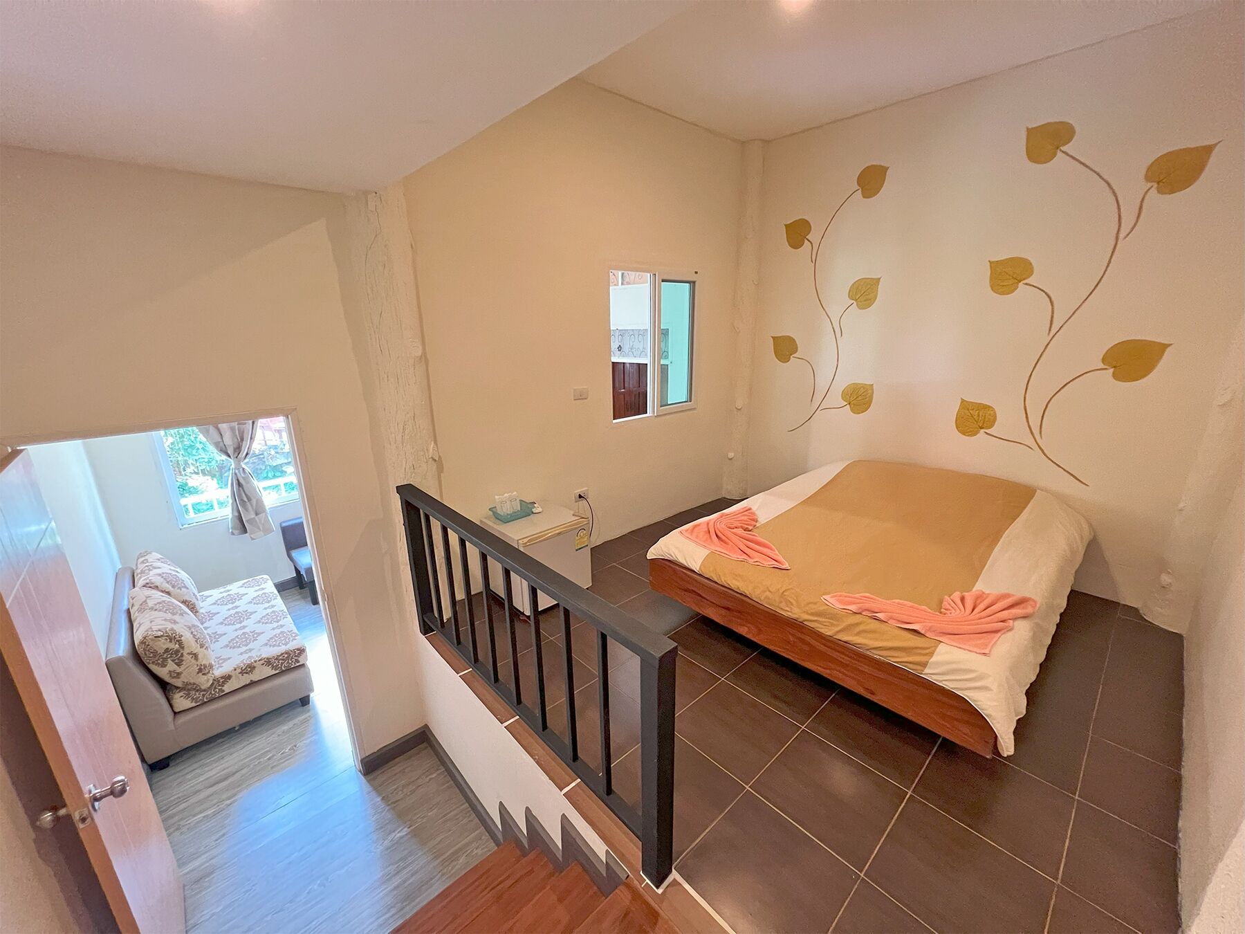 Un dormitorio con cama, ventana y escalera.