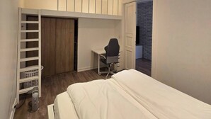A bedroom with a bed, a desk, a chair, a wardrobe, and a small balcony. - H21A-Central-Cozy Spacious Suits family-3 rooms (Oslo)