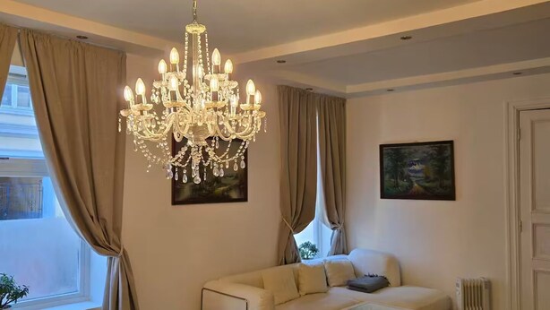 A living room with a chandelier, beige sofa, and a dining table. - H21A-Central-Cozy Spacious Suits family-3 rooms (Oslo)