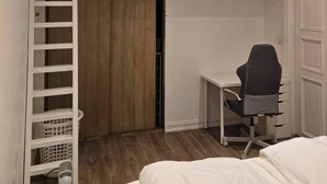 Um quarto com cama beliche, escrivaninha e cadeira.