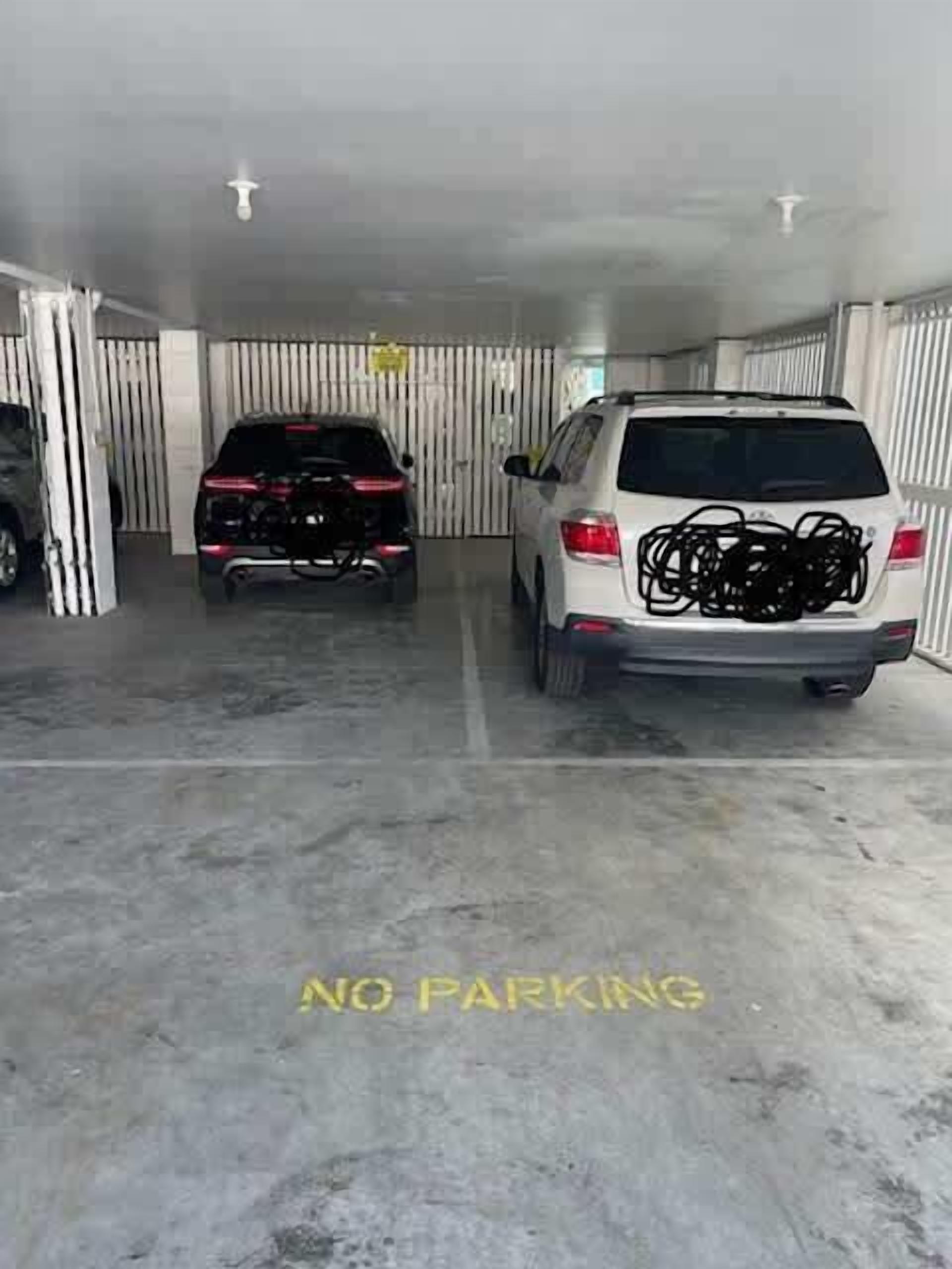 A parking garage with a 'NO PARKING' sign on the floor.