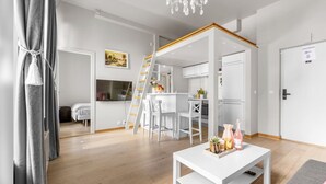 Ein modernes Interieur mit Essbereich, Küche und einer Treppe zu einer oberen Ebene.