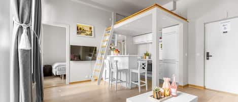 A modern interior with a dining area, kitchen, and a staircase leading to an upper level.